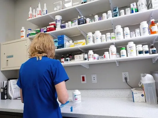Woman working in pharmacy. 