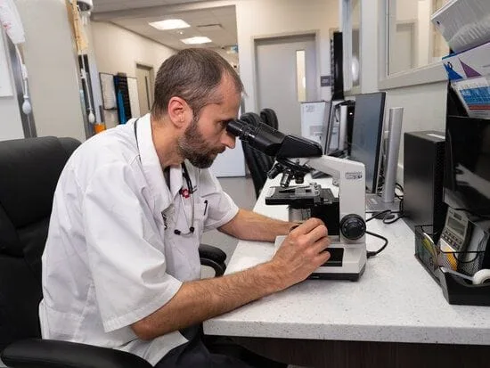 Photo of doctor looking through microscope