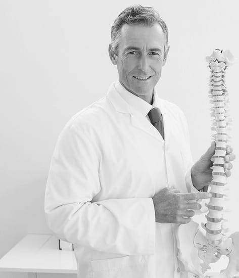 Chiropractor pointing to spine model