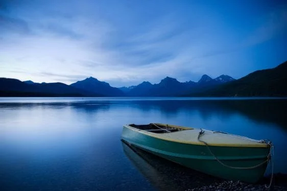 Calm Lake Water with mountains in the background and a boat floating