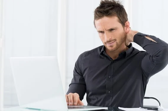Man holding neck from chiropractor neck pain