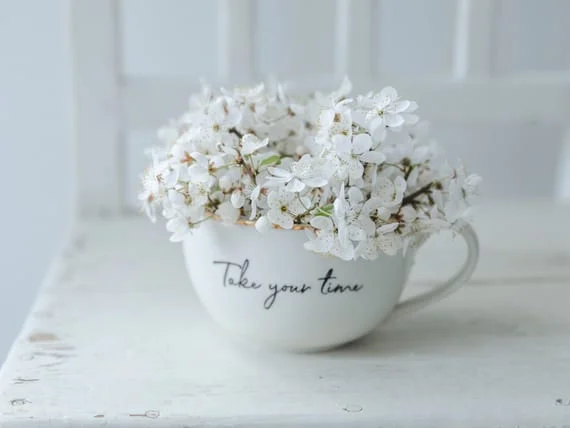 cup of flowers saying "take your time"