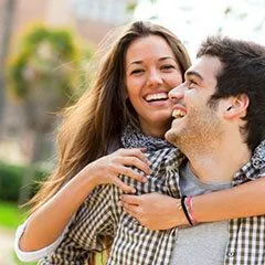 young couple outdoors laughing together, cosmetic dentistry Cypress, TX
