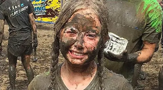 childs muddy smiling face