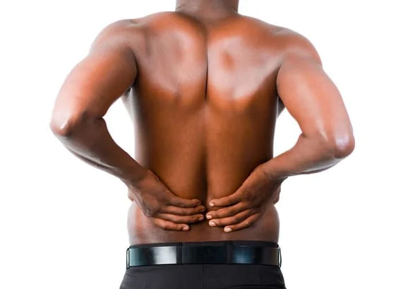 A Black man holding his lower back