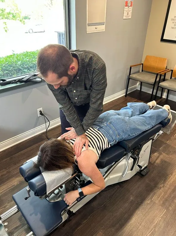 chiropractor adjusting patient on table