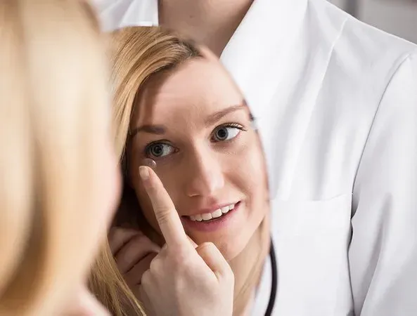 woman putting contact lens on eyes