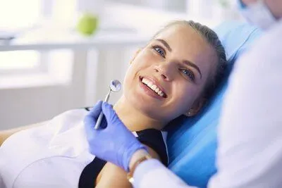 blond girl in dental chair, smiling looking up at dentist Katy, TX