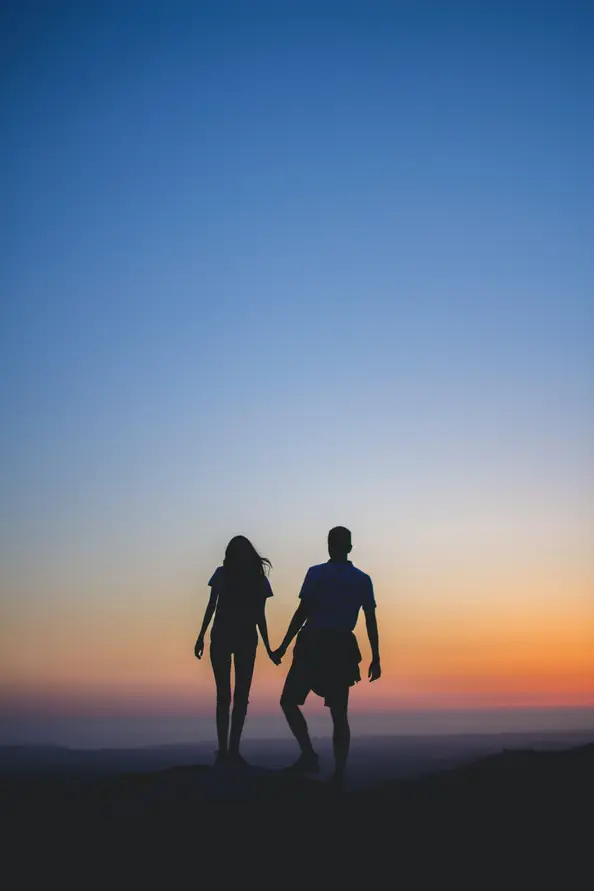 Couple holding hands at sunset