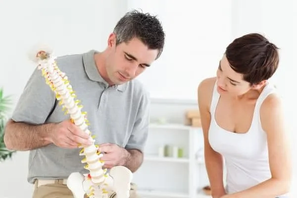 Chiropractor at Back on Track Chiropractic & Wellness Center showing a patient a model of their spine