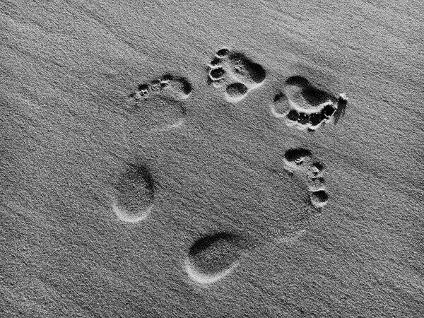 two sets of footprints in the sand