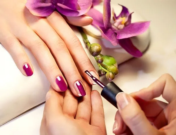 Image of a person having nails painted pink