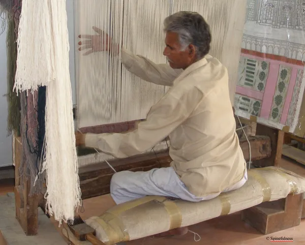 Man sitting straight and working at loom