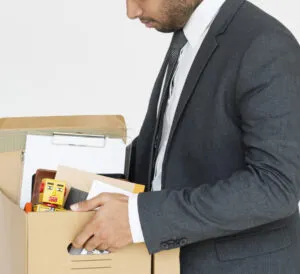 man in suit carrying a box with his personal belongings