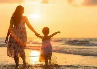 mother walking on beach with child