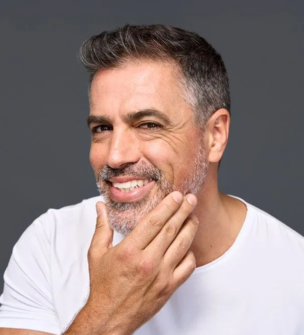 smiling man touching his face