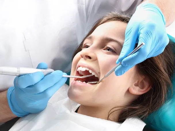 young girl in dentist chair with mouth open getting dental work done, family dentist Lexington, KY