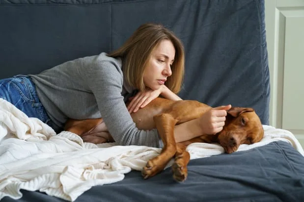 woman taking care of an old dog