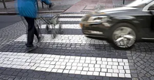 Senior citizen crossing street with fast car approaching