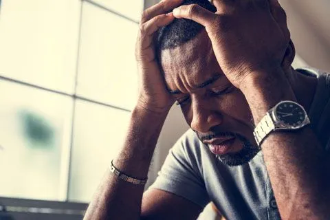 Man sitting depressed holding head