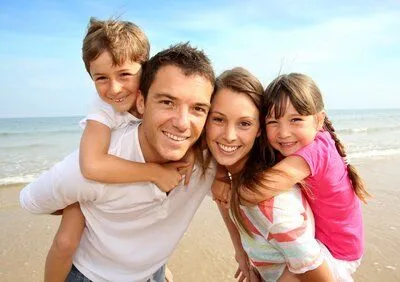 smiling family with kids on beach, dentist Sherman Oaks, CA