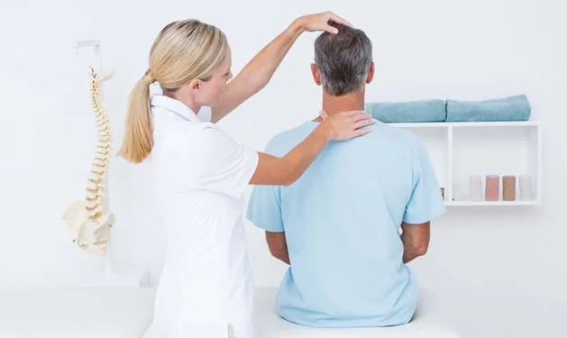 chiropractor with a patient during a chiropractic exam to treat neck pain