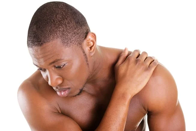 man holding his shoulder because he is suffering from pain