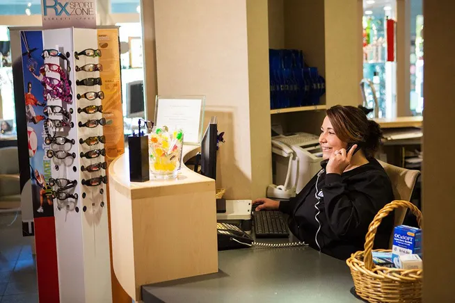 image of front desk assistant helping person fill out paperwork. 