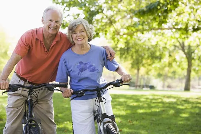 Happy elderly couple biking