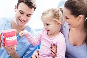 pediatric dentist showing little girl and her mom a model of teeth, family dentist Frederick, MD family dentistry