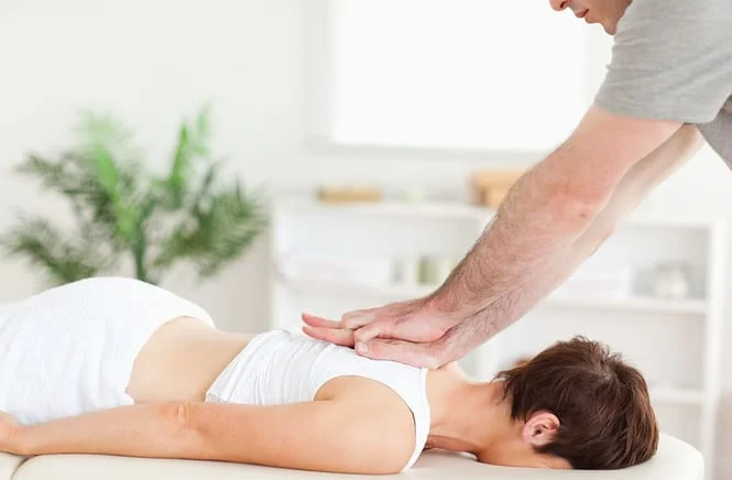 woman receiving a massage from a chiropractor for upper back pain