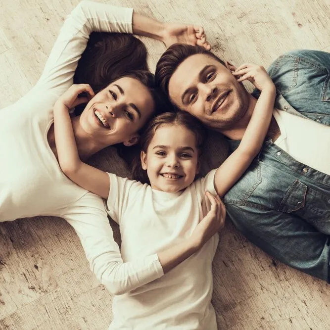 Happy parents and child lying together looking upward