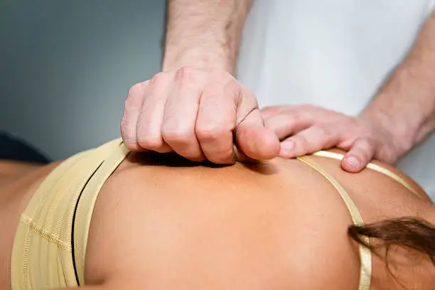 Chiropractor is doing Myofascial Release Technique to the patient.