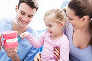 dentist showing toddler girl and mom model of teeth, family dentistry Cockeysville dentist
