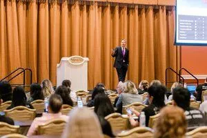 Dr. Baggott lecturing to crowd in auditorium about Invisalign, West Allis, WI Invisalign provider