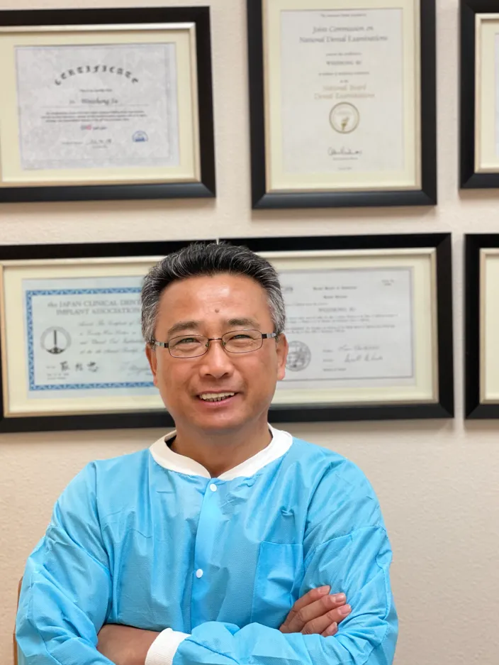Doctor Andy Su Yuchi in front of his licenses, degrees, awards, and accolades.