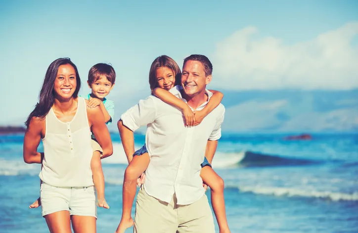 family playing on beach near ocean waves, comprehensive dental care Narberth, PA dentist