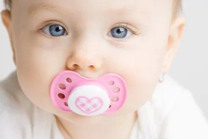 blue-eyed baby girl with pink pacifier, children's dentistry Durham, NC dentist