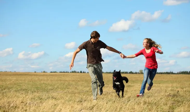 Owners playing with dog outside