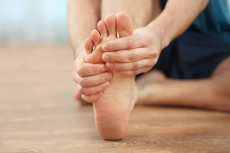 Young man experiencing plantar faciitis pain