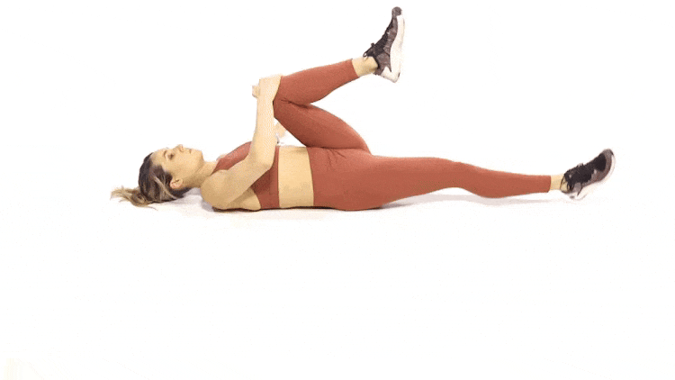 A woman performing the Supine Figure-four stretch.