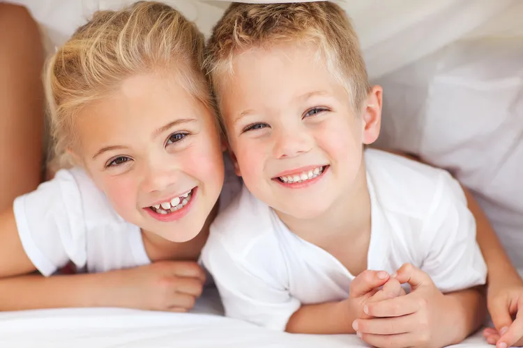 young blond girl hugging blond boy, smiling. dental sealants Augusta, GA 