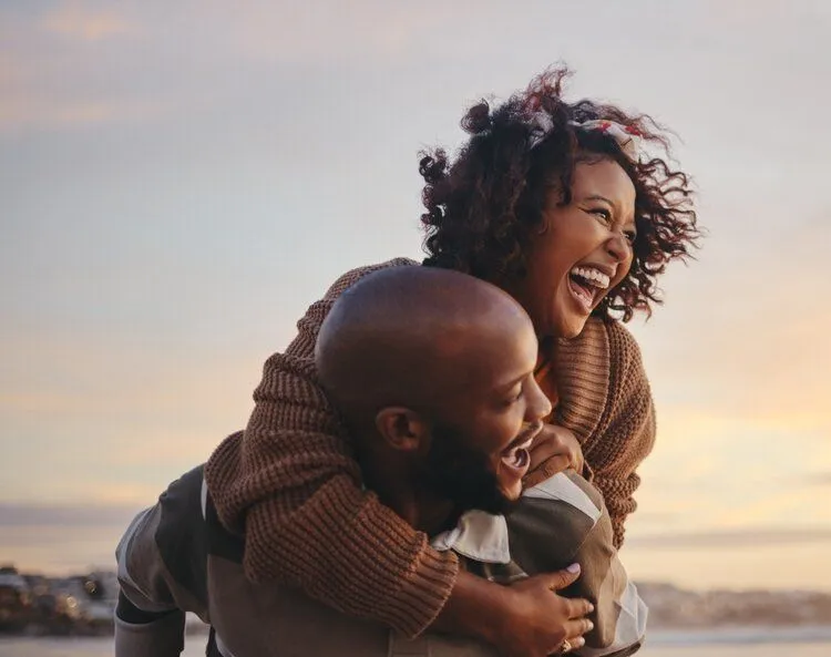 Couple laughing while having a piggyback ride