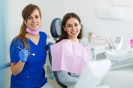 dental hygienist standing next to female patient in dental chair, teeth cleaning Fond du Lac, WI dentist