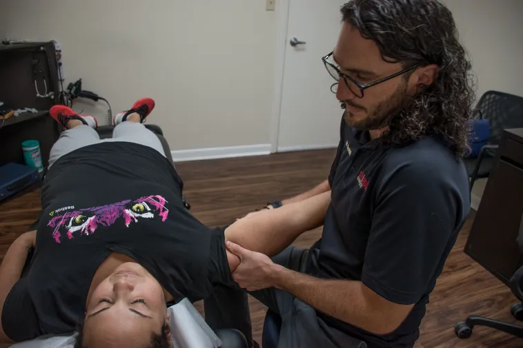 Dr. Stumpff doing some shoulder adjustment to the patient who suffers shoulder Bursitis