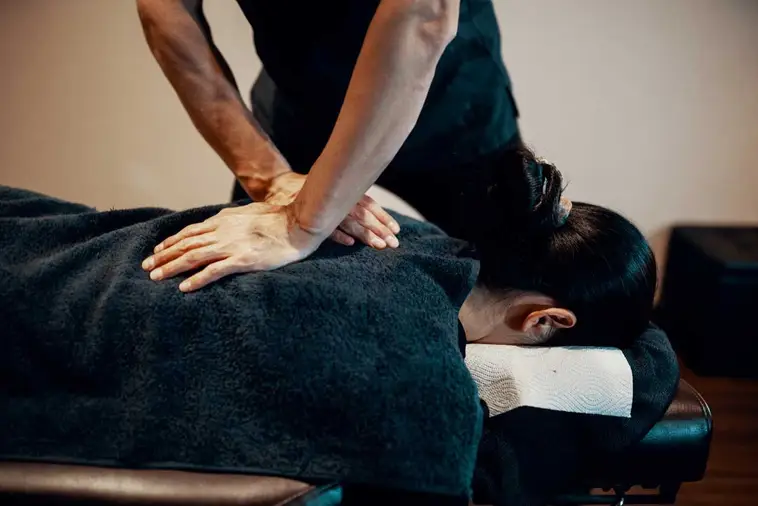 Chiropractor doing some chiropractic treatment to the patient who suffers from whiplash injury.