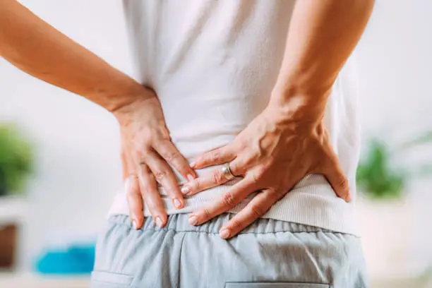 Man holding his back feeling of too much pain caused by Sciatica
