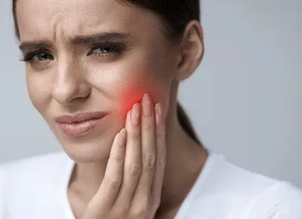 woman wincing, holding jaw in pain, emergency dentist Montclair, NJ emergency dental care
