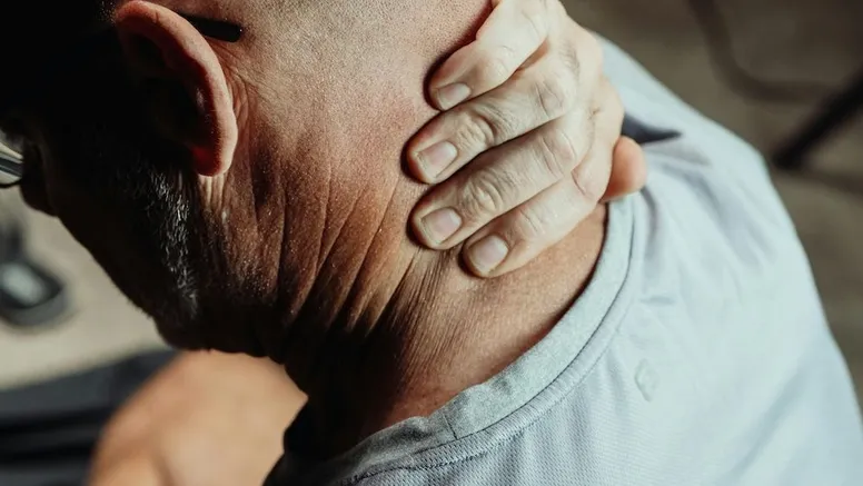 Man rubbing his neck because of neck pain