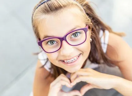 young girl wearing purple glasses smiling with braces in her mouth, braces New Baltimore, MI orthodontics